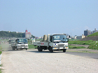 復旧資材の輸送訓練のため緊急河川敷道路を走行する大型トラック