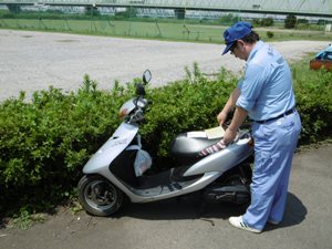 不法侵入車両（バイク）に警告書を貼り付けている状況