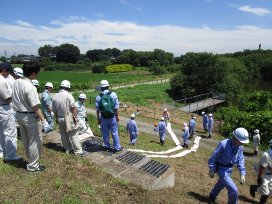 道路下配管とホースを接続後、ホースとポンプを排水が必要な川（江川側）に投入します。※訓練時は平常水位のため、ポンプの投入は行いませんでした。