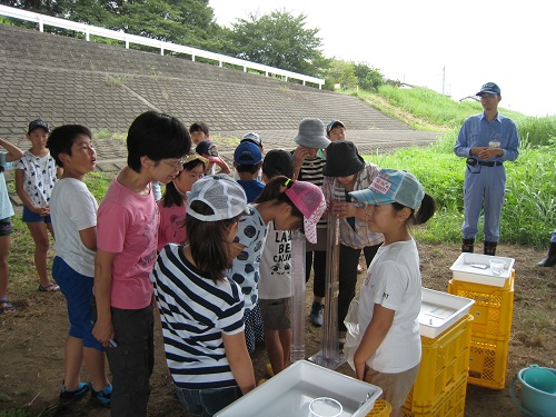 この川の水の透明度を計っています。