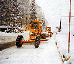 新雪をグレーダーで路肩にかき寄せ、円滑な交通確保